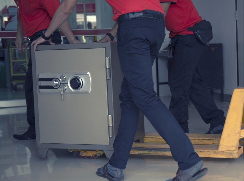 Two men moving a heavy safe securely.